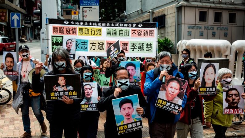 Manifestantes prodemocráticos de la Alianza de Hong Kong sostienen pancartas de activistas de derechos humanos detenidos mientras marchan hacia la oficina de enlace china en Hong Kong el 19 de febrero de 2020, en protesta por la detención en Beijing del destacado activista anticorrupción Xu Zhiyong. (ISAAC LAWRENCE/AFP vía Getty Images)