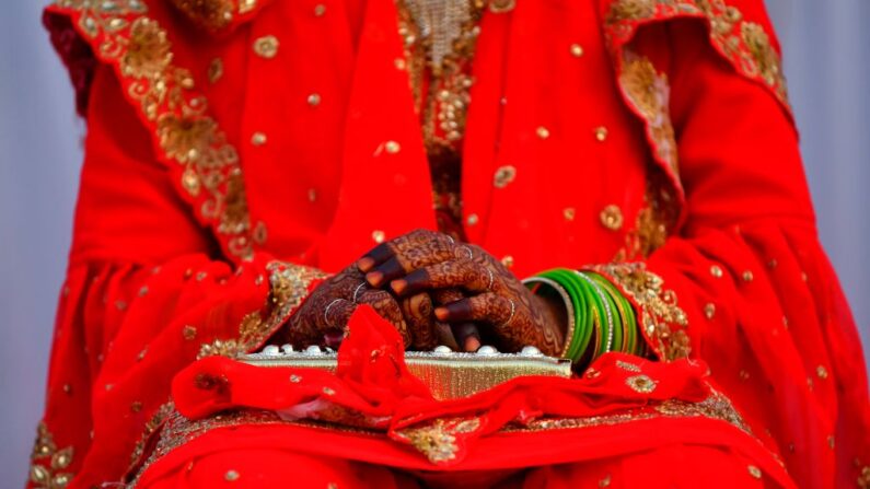 Una novia musulmana con las manos decoradas se sienta en un escenario durante un evento de matrimonio masivo en Mumbai (India) el 14 de febrero de 2021. (Indranil Mukherjee/AFP vía Getty Images)