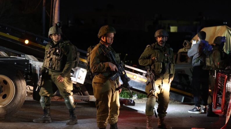 Soldados israelíes se reúnen en el lugar de un ataque por embestida cerca de la localidad de Beit Ummar, al norte de la ciudad de Hebrón, en la Cisjordania ocupada, el 1 de abril de 2023. (Ahmad Gharabli/AFP vía Getty Images)