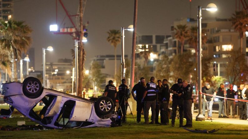 La policía israelí se reúne junto a un coche volcado en el lugar de un atentado en Tel Aviv (Israel) el 7 de abril de 2023. (Ahmad Gharabli/AFP vía Getty Images)