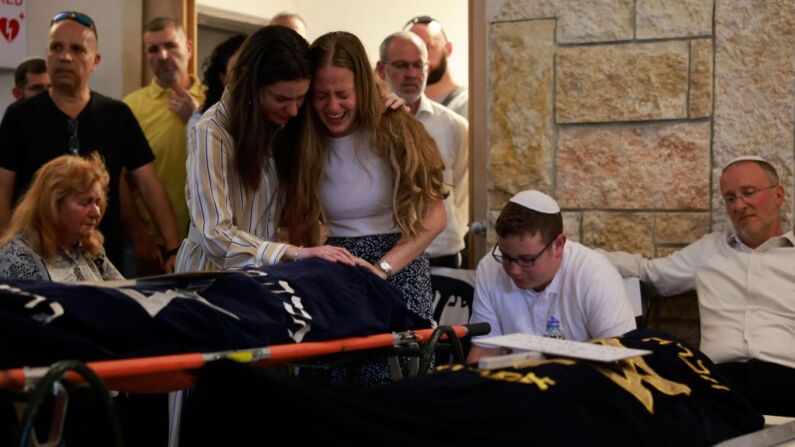 Familiares participan en el funeral de las hermanas británico-israelíes Rina y Maia Dee en el cementerio del asentamiento de Kfar Etzion, en Cisjordania ocupada, el 9 de abril de 2023. - El 7 de abril, dos hermanas británico-israelíes murieron y su madre resultó gravemente herida en un tiroteo en Cisjordania, y el ejército israelí dijo que había iniciado una persecución de los autores. (MENAHEM KAHANA/AFP vía Getty Images)