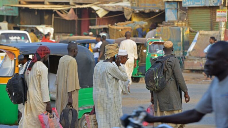 Varios hombres caminan por una calle de Umdurman, ciudad gemela de Jartum (Sudán), el 16 de abril de 2023. (AFP vía Getty Images)