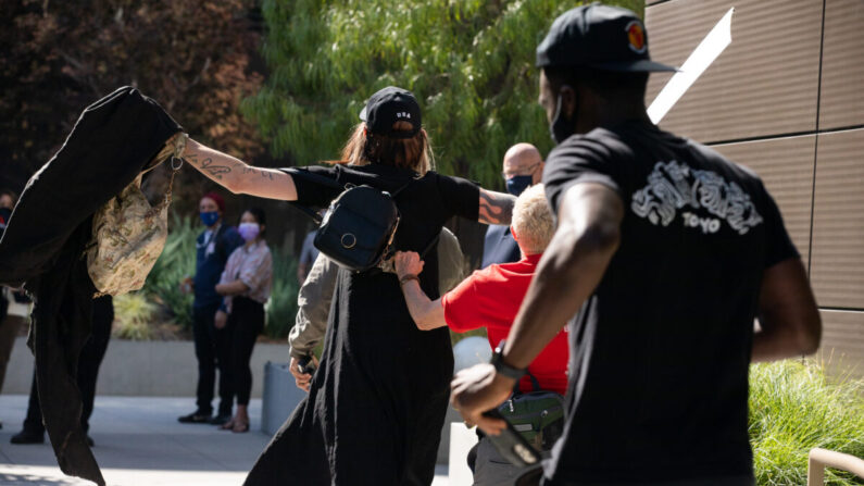 Un miembro transgénero de Antifa ataca a un activista gay que sostiene carteles que comunican la libertad de expresión en Los Ángeles, California, el 10 de octubre de 2021. (John Fredricks/The Epoch Times)