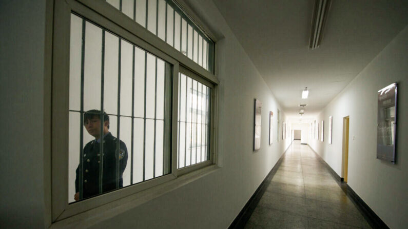 Un guardia mira por la ventana de un pasillo del interior del Centro de Detención nº 1 durante una visita guiada por el gobierno en Beijing el 25 de octubre de 2012. (Ed Jones/AFP vía Getty Images)