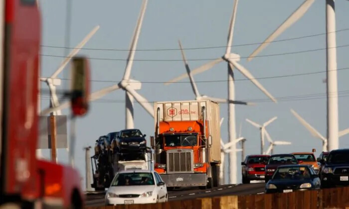 Autos y camiones que producen emisiones pasan por un parque eólico a lo largo de la autopista de California. Los estadounidenses están profundamente polarizados en sus creencias sobre el cambio climático y los investigadores quieren saber por qué. (David McNew/Getty Images)
