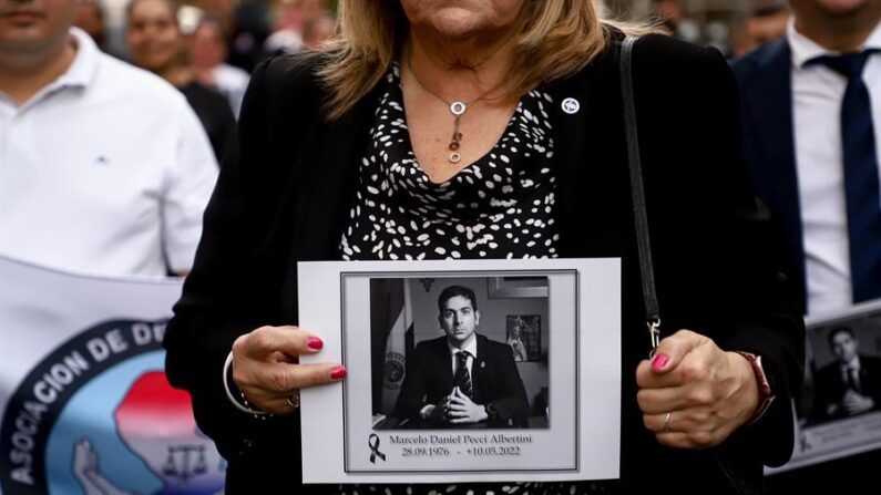 Mujer sostiene foto del exfiscal paraguayo Marcelo Pecci, quien fue asesinado en Colombia, durante una marcha en repudio por su homicidio, en Asunción (Paraguay), el 13 de mayo de 2022. EFE/Nathalia Aguilar
