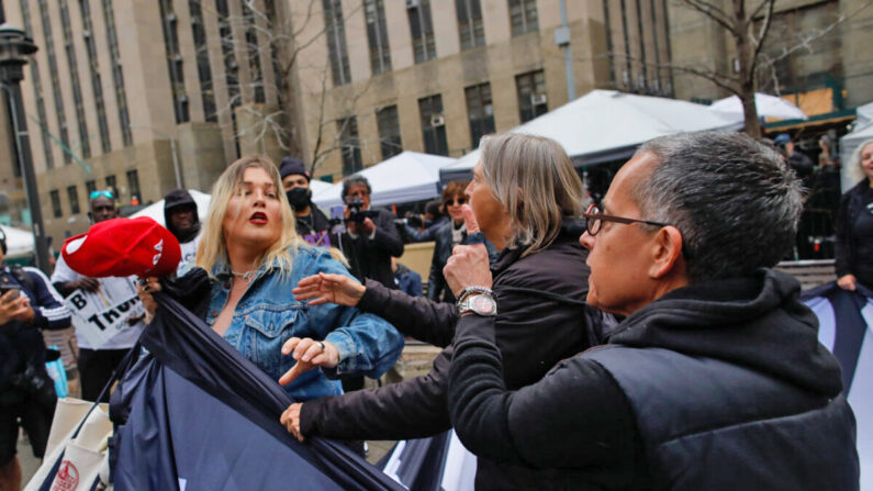 Una partidaria de Trump (I) retira una pancarta de los manifestantes anti-Trump frente al Tribunal Penal de Manhattan el 4 de abril de 2023 en Nueva York. (Kena Betancur/Getty Images)
