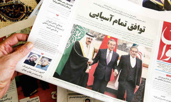 Un hombre sostiene un periódico local que informa sobre el acuerdo negociado por China entre Irán y Arabia Saudita para restablecer los lazos entre los dos países, en la capital iraní, Teherán, el 11 de marzo de 2023. (Atta Kenare/AFP a través de Getty Images)
