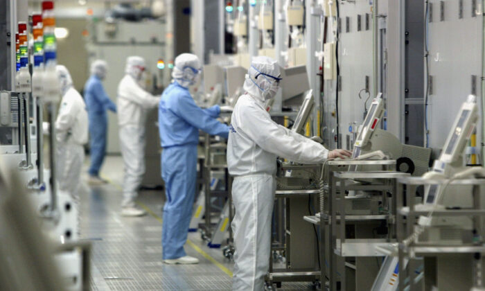Técnicos trabajando en la empresa de semiconductores, Renesas Technology Corp., en Ibaraki, Japón, el 17 de junio de 2004. (Koichi Kamoshida/Getty Images)
