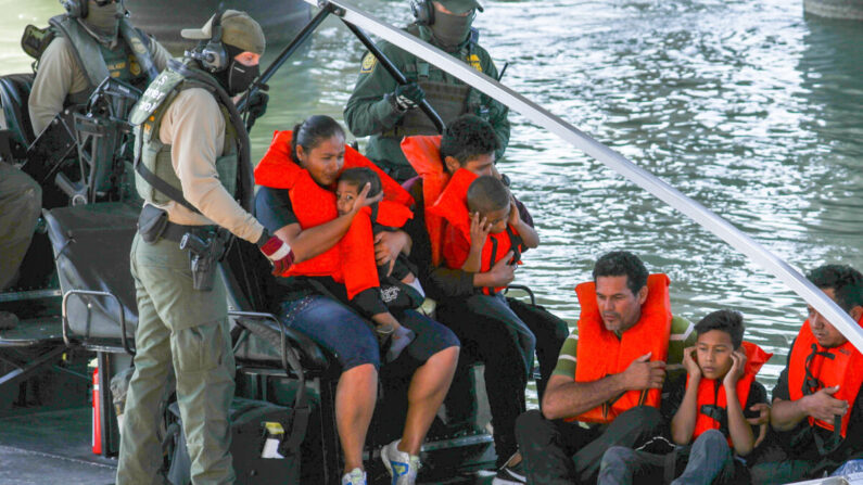 Personas que cruzan ilegalmente la frontera son rescatados por agentes en un barco de Aduanas y Protección Fronteriza de Estados Unidos mientras se quedan atascados a medio camino a través del Río Grande desde México hacia Eagle Pass, Texas, el 16 de febrero de 2019. (Charlotte Cuthbertson/The Epoch Times)
