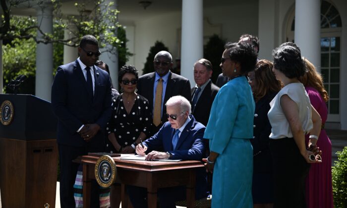 El presidente Joe Biden (Ce) firma una orden ejecutiva sobre nuevas acciones para promover la justicia ambiental, en el Rose Garden de la Casa Blanca el 21 de abril de 2023. (Brendan Smialowski/AFP vía Getty Images)