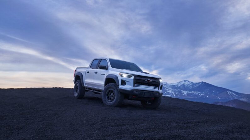 Front 3/4 view of the Colorado ZR2 Bison with headlights on and mountains in the background.