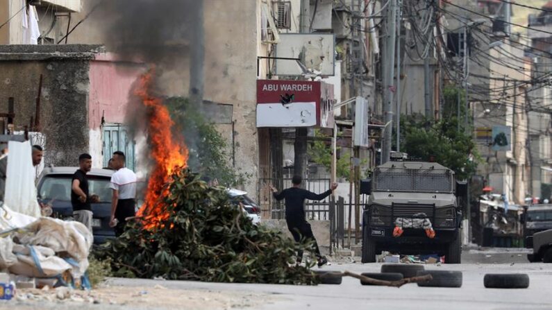 Palestinos tiran piedras a los soldados israelíes en enfrentamientos en el campo de refugiados de Balata en la ciudad de Nablus, en el norte de Cisjordania ocupada, territorio que vive su mayor pico de violencia desde la Segunda Intifada con 114 muertos en lo que va de año. EFE/Alaa Badarneh