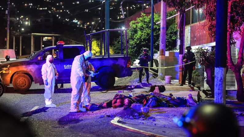 Peritos examinan el sitio donde fueron localizadas tres personas sin vida envueltas en sábanas, en el balneario de Acapulco, estado de Guerrero (México), el 18 de mayo de 2023. EFE/David Guzmán
