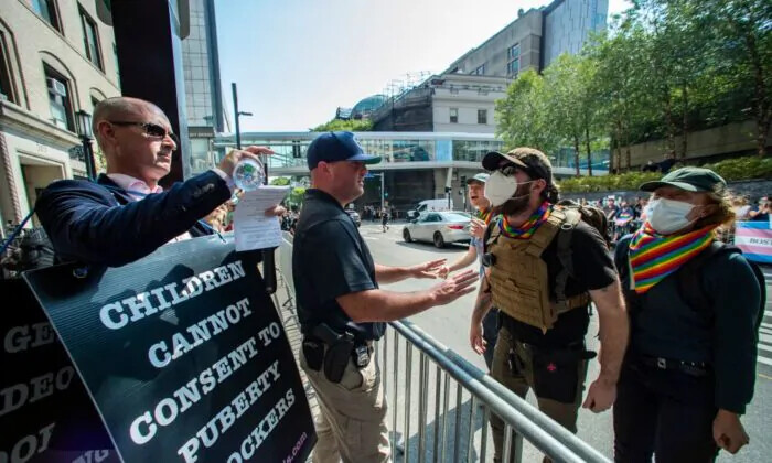 La policía se interpone entre el activista antitrans Chris Elston (Izq.) y los contramanifestantes (Der.) mientras se enfrentan afuera del Boston Childrens Hospital en Boston, Massachusetts, el 18 de septiembre de 2022. (Joseph Prezioso/AFP vía Getty Images)

