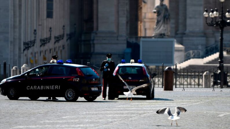Policías de Carabinieri italianos patrullan cerca de la Plaza de San Pedro (Detrás) en la frontera entre Italia y el Vaticano, el 19 de marzo de 2020 en Roma. (Filippo Monteforte/AFP vía Getty Images)