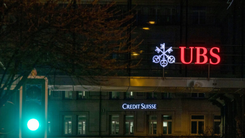 Una señal de tráfico se ve delante de los logotipos de los bancos suizos Credit Suisse y UBS el día después de que sus acciones cayeran aproximadamente un 30% el 16 de marzo de 2023 en Zúrich, Suiza. (Arnd Wiegmann/Getty Images)
