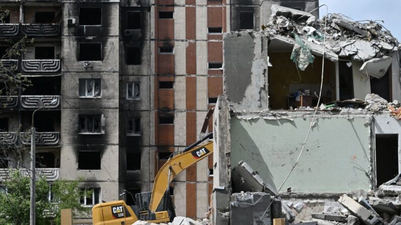 Unos trabajadores desmontan un edificio de viviendas gravemente dañado en Irpin, el 4 de mayo de 2023, en medio de la invasión rusa de Ucrania. (Genya Savilov/AFP vía Getty Images)