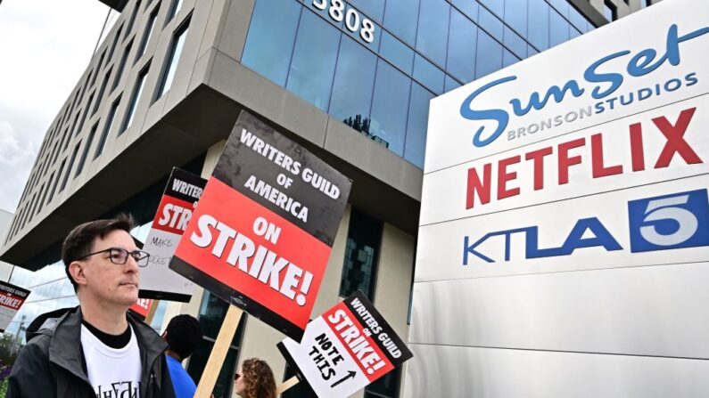 El guionista Eric Heisserer sostiene su cartel en el cuarto día de huelga del Sindicato de Guionistas de América frente a Netflix en Hollywood, California, el 5 de mayo de 2023. (FREDERIC J. BROWN/AFP vía Getty Images)