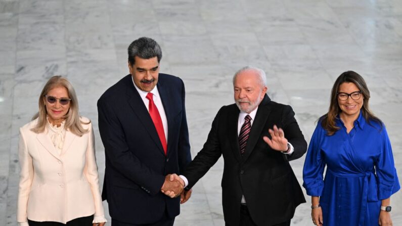 El líder del régimen de Venezuela, Nicolás Maduro (2do. a la Izq), y el presidente de Brasil, Luiz Inácio Lula da Silva (2do. a la Der.), se dan la mano, acompañados por la esposa de Maduro, Cilia Flores (Izq.), y la primera dama de Brasil, Rosangela "Janja" da Silva, durante una ceremonia de bienvenida en el Palacio de Planalto, en Brasilia, el 29 de mayo de 2023. (EVARISTO SA/AFP vía Getty Images)