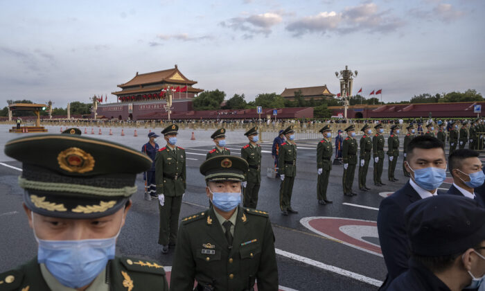 Agentes de policía y seguridad bloquean el paso a la Plaza de Tiananmen y a la Ciudad Prohibida, en Beijing, mientras realizan el control de los presentes después de una ceremonia oficial de izado de bandera para conmemorar el Día Nacional de China, el 1 de octubre de 2021. (Kevin Frayer/Getty Images)