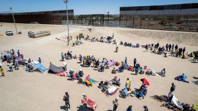 En una vista aérea, unos inmigrantes se reúnen en un campamento de migrantes improvisado junto a la valla fronteriza entre Estados Unidos y México el 11 de mayo de 2023 en El Paso, Texas. (John Moore/Getty Images)