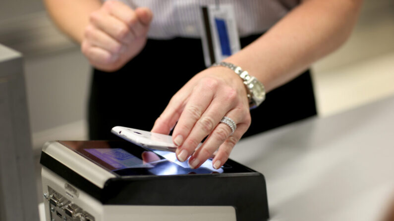 Un viajero utiliza una aplicación móvil para agilizar el control de pasaportes y clientes en el Aeropuerto Internacional de Miami en Miami, Florida, el 4 de marzo de 2015. (Joe Raedle/Getty Images)