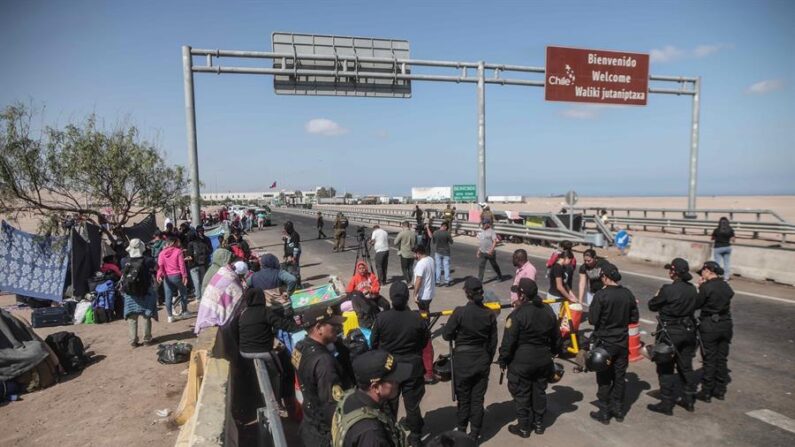 Fotografía de archivo tomada el pasado 27 de abril en la que se registró a un grupo de migrantes al esperan en el paso fronterizo de control entre Santa Rosa (Perú) y Chacalluta (Chile). EFE/Aldair Mejía