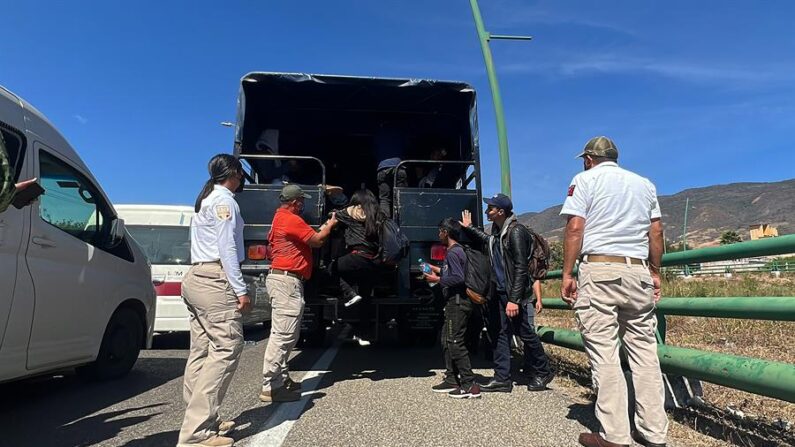 Fotografía de archivo de integrantes del Instituto Nacional de Migración que ayudan a descender a migrantes que viajaban en un tráiler. EFE/Carlos López
