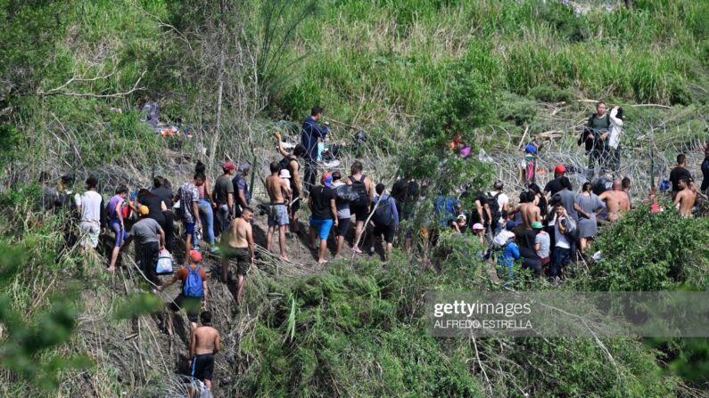 Migrantes intentan entrar en Estados Unidos a través del río Bravo (Río Grande en EE. UU.), donde la Guardia Nacional estadounidense está reforzado una valla de alambre de púas a lo largo del río fronterizo. Imagen desde Matamoros, estado de Tamaulipas, México, el 10 de mayo de 2023. (Alfredo Estrella / AFP vía Getty Images)