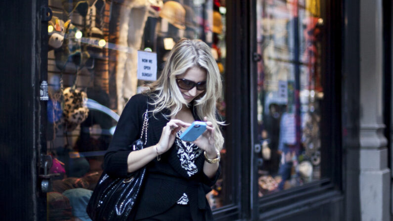 Una mujer revisa su teléfono en una foto de archivo. (The Epoch Times)