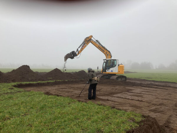 Un excavador e investigadores trabajan en la excavación y búsqueda de artefactos de la época vikinga en un campo de Blåtand, Dinamarca. (Fotos de Nordjyske Museer, Dinamarca)