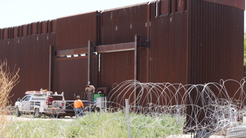 Contratistas independientes trabajan cerca de una sección de la valla fronteriza en San Luis, Arizona, el 4 de mayo de 2023. (Allan Stein/The Epoch Times)