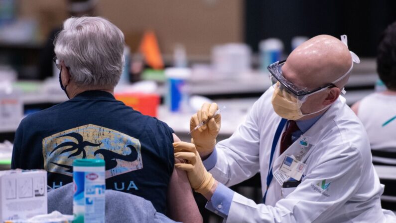 John Corman, entonces director clínico de Virginia Mason, administra una vacuna COVID-19 en el Amazon Meeting Center de Seattle el 24 de enero de 2021. (Grant Hindsley/AFP vía Getty Images)