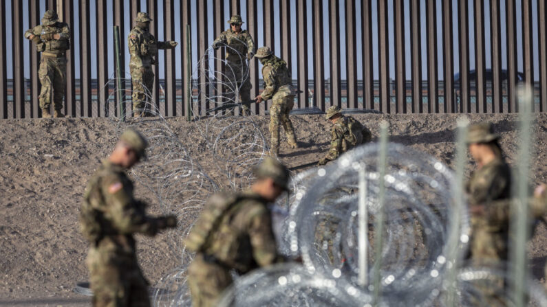 Soldados de la Guardia Nacional de Texas desenrollan alambre de púas cerca de la valla fronteriza entre Estados Unidos y México en El Paso, Texas, el 10 de mayo de 2023. (John Moore/Getty Images)
