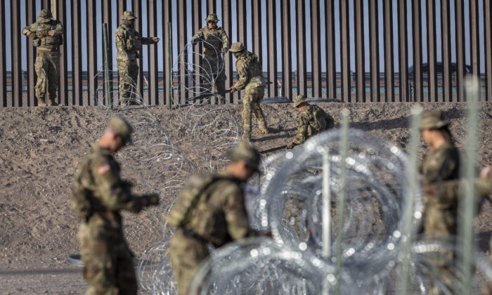 Soldados de la Guardia Nacional de Texas desenrollan alambre de concertina cerca de la valla fronteriza entre Estados Unidos y México en El Paso, Texas, el 10 de mayo de 2023. (John Moore/Getty Images)