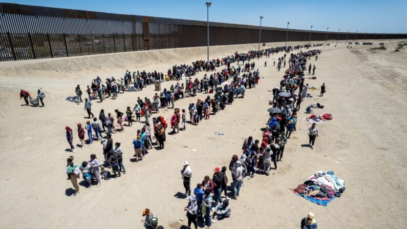 En una vista aérea, inmigrantes hacen fila para ser procesados para presentar solicitudes de asilo en un campamento improvisado de migrantes en El Paso, Texas, el 11 de mayo de 2023. (John Moore/Getty Images)
