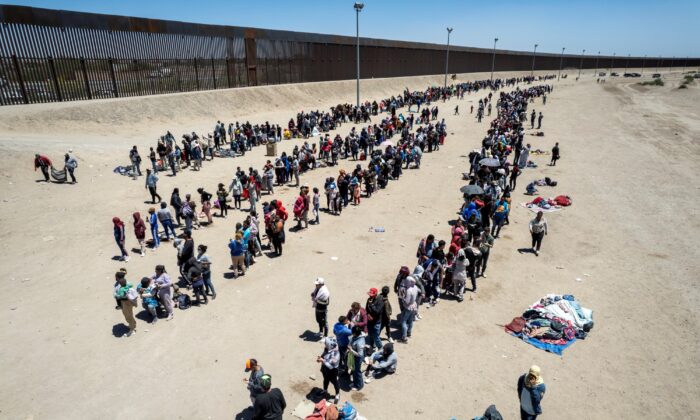 Vista aérea con migrantes haciendo fila para ser procesados para hacer solicitudes de asilo en un campamento improvisado el 11 de mayo de 2023 en El Paso, Texas. (John Moore/Getty Images)