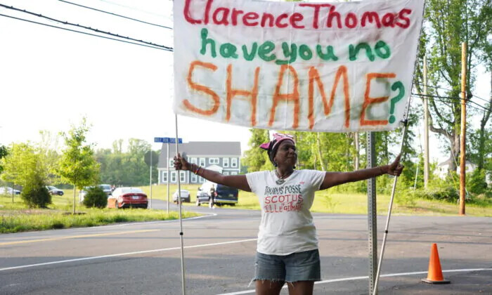 La manifestante Nadine Seiler sostiene una pancarta durante una protesta por el aborto cerca de la casa del juez Clarence Thomas el 11 de mayo. (Joseph Lord/The Epoch Times)