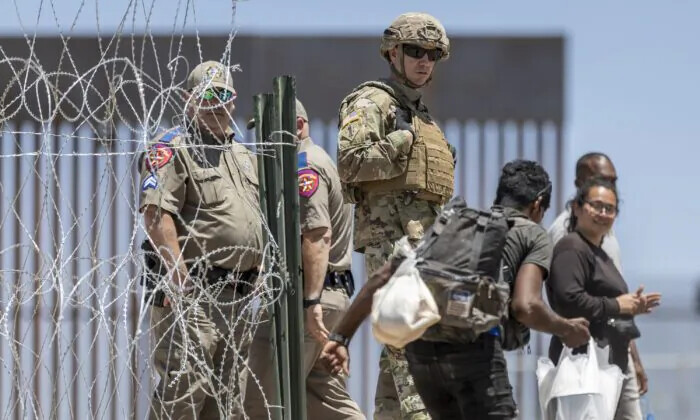 Un soldado de la Guardia Nacional de Texas observa cómo un migrante entra en un campamento de migrantes improvisado, en El Paso, Texas, el 11 de mayo de 2023. (John Moore/Getty Images)