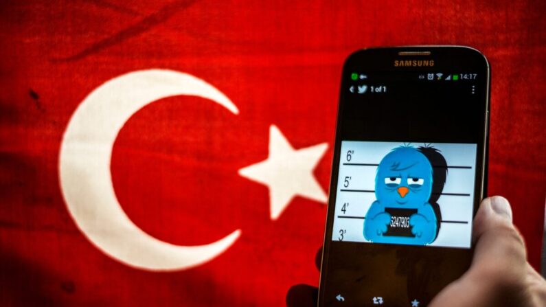 Una imagen que representa una ficha policial del pájaro de Twitter se ve en un smartphone con una bandera turca el 26 de marzo de 2014. (Ozan Kose/AFP vía Getty Images)
