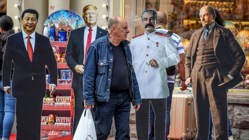 Un hombre camina junto a recortes de cartón del presidente chino Xi Jinping, el presidente estadounidense Donald Trump y los líderes soviéticos Joseph Stalin y Vladimir Lenin en el centro de Moscú el 7 de agosto de 2019. (Yuri Kadobnov/AFP vía Getty Images)
