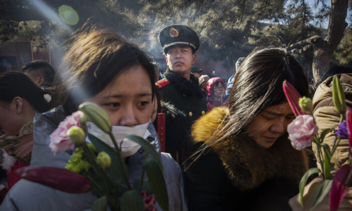 Un policía paramilitar vigila a fieles chinos mientras rezan en el templo Yongchegong Lama en Pekín, China, el 8 de febrero de 2016. (Kevin Frayer/Getty Images)