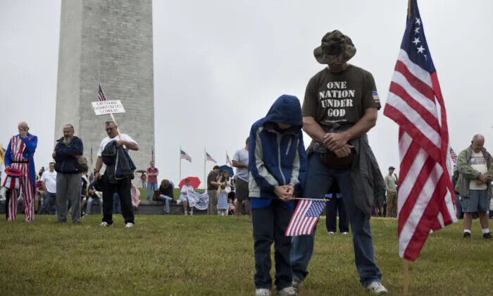 La gente inclina la cabeza en oración durante un mitin en el National Mall cerca del Monumento a Washington, en Washington, D.C., el 12 de septiembre de 2010. (Brendan Smialowski/Getty Images)
