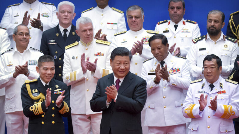 El líder del Partido Comunista Chino, Xi Jinping (centro), y oficiales navales chinos y extranjeros aplauden después de una foto de grupo durante un evento para conmemorar el 70 aniversario de la Armada del Ejército Popular de Liberación (EPL) en Qingdao, en la provincia oriental china de Shandong, el 23 de abril de 2019. (Mark Schiefelbein/AFP vía Getty Images)