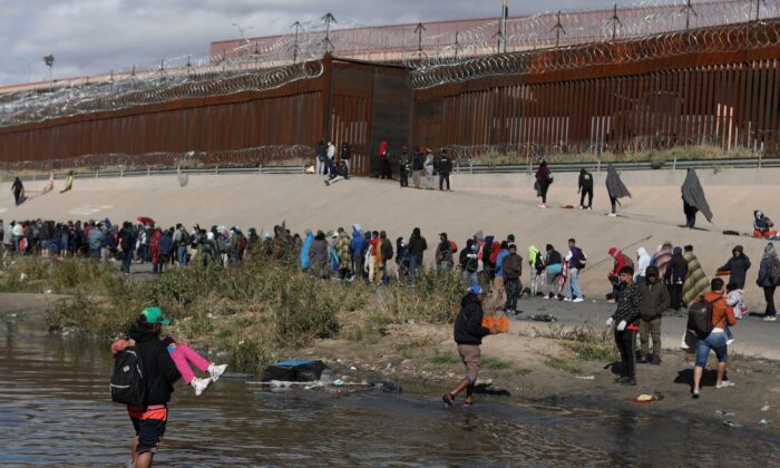 Inmigrantes ilegales caminan a través del Río Grande para entregarse a agentes de la Patrulla Fronteriza de Estados Unidos en El Paso, Texas, visto desde Ciudad Juárez, estado de Chihuahua, México, el 13 de diciembre de 2022. (Herika Martinez/AFP vía Getty Images)