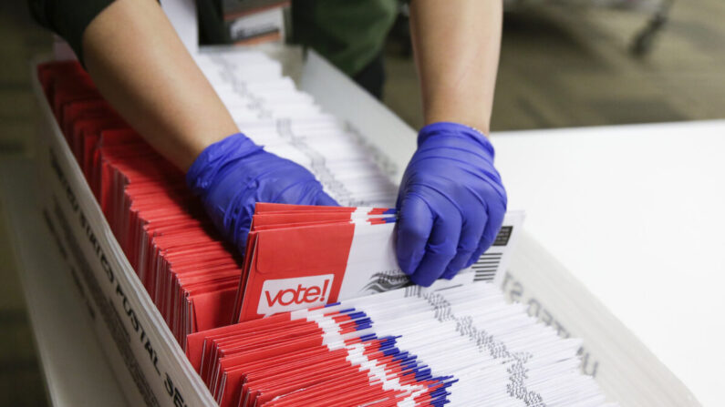 Trabajadores electorales clasifican papeletas de voto por correo para las primarias presidenciales en King County Elections en Renton, Washington, el 10 de marzo de 2020. (Jason Redmond/AFP vía Getty Images)

