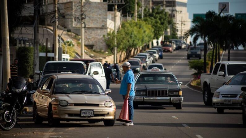 Personas hacen fila junto a sus vehículos mientras esperan para surtir combustible, 13 de junio de 2023, en Maracaibo (Venezuela). EFE/ Henry Chirinos