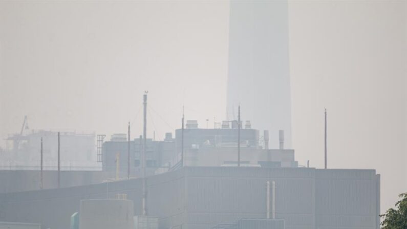 Fotografía de la icónica Torre CN (al fondo) prácticamente invisible debido al humo de los incendios forestales de la provincia de Quebec, este 30 de junio de 2023 desde una calle en el centro de la ciudad de Toronto (Canadá). EFE/Julio César Rivas