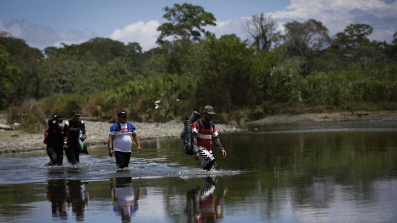 Personas migrantes cruzan el río Tuquesa, en Darién (Panamá), en una fotografía de archivo. EFE/ Bienvenido Velasco